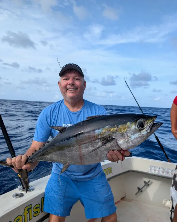 Angler holding a tuna on a boat offshore