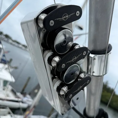 Bravo ACR unit clamped to a rigger pole: pulley covers engraved with the ACR mark, a marina behind